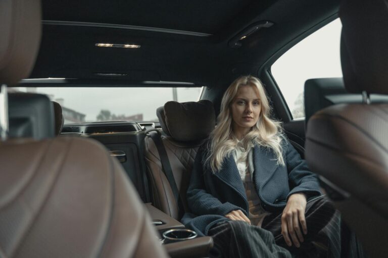 Woman in Blue Coat Sitting on Back Seat of a Car